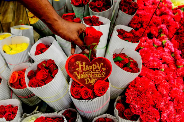 A florist arranges roses flowers at a shop ahead of Valentine's Day. (Photo by ARUN SANKAR/AFP via Getty Images)