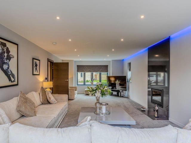 A spacious lounge with spotlights to the ceiling.