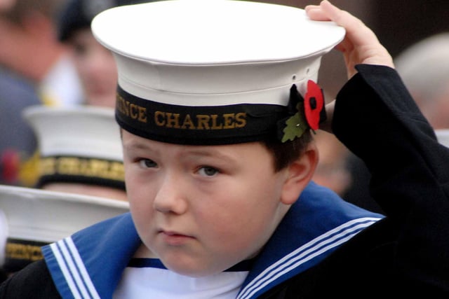 A young navy cadet adjusts his cap to get ready for the Remembrance service at the Civic Centre.