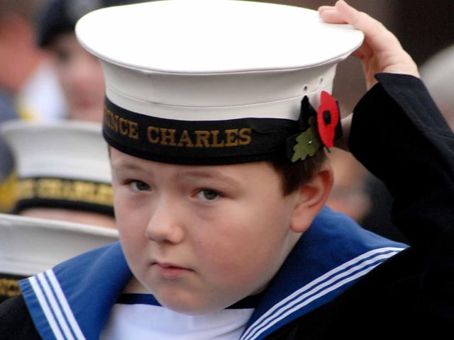 A young navy cadet adjusts his cap to get ready for the Remembrance service at the Civic Centre.