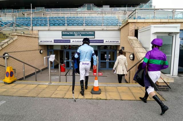 Jockeys return to their makeshift weighing room in the exhibition hall at Doncaster Racecourse. Photo by Alan Crowhurst/Getty Images