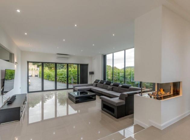 The spacious sitting room is bathed in an abundance of natural light from the huge windows and offers access to the terrace from the bi-folding glass doors.