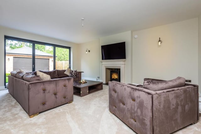 This formal lounge has a modern feature fireplace with woodburning stove, plus bi-fold doors out to the gardens.