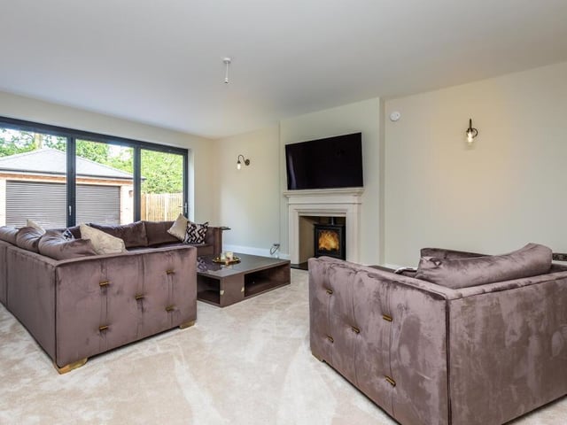 This formal lounge has a modern feature fireplace with woodburning stove, plus bi-fold doors out to the gardens.