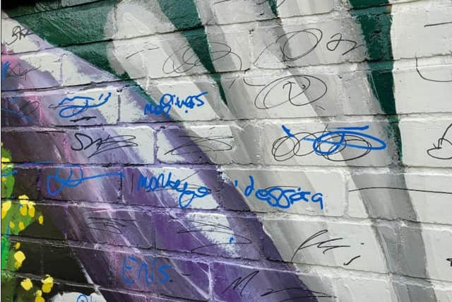 The mural has been covered in graffiti 'tags'