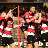 The Doncaster Rovers players celebrate opening the scoring against Everton.