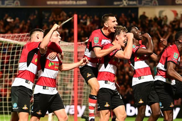 The Doncaster Rovers players celebrate opening the scoring against Everton.