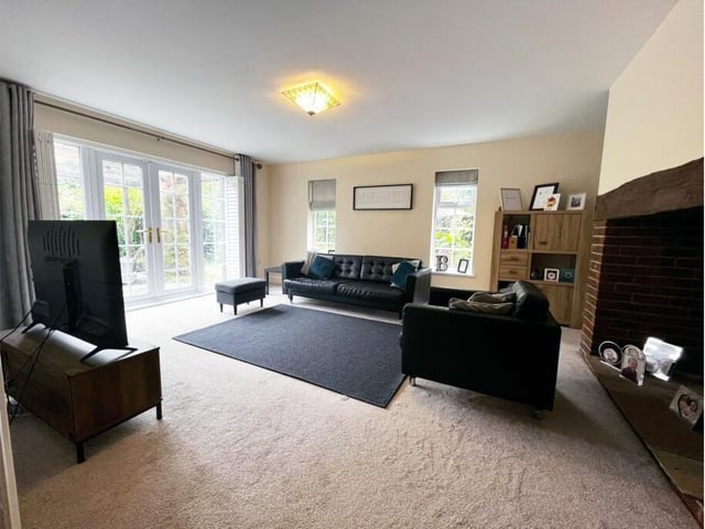 A lounge with large feature fireplace has double doors to outside - ideal for summer entertaining.