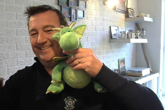 Alan Roberts holding a dragon toy.
