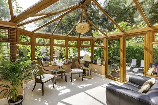 The large garden room is surrounded by greenery.