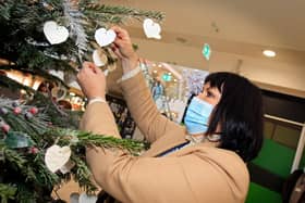 Karen Staniforth, Frenchgate Centre manager, pictured hanging a decoration on the Memory Tree. Picture: NDFP-07-12-21-MemoryTree 3-NMSY