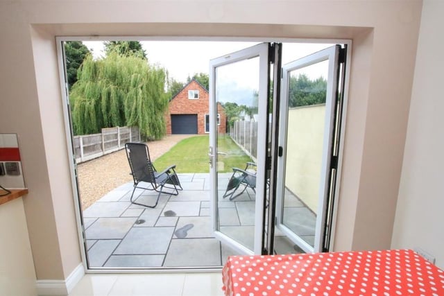 Bi-folding doors open to the enclosed rear garden with the two-storey additional building.