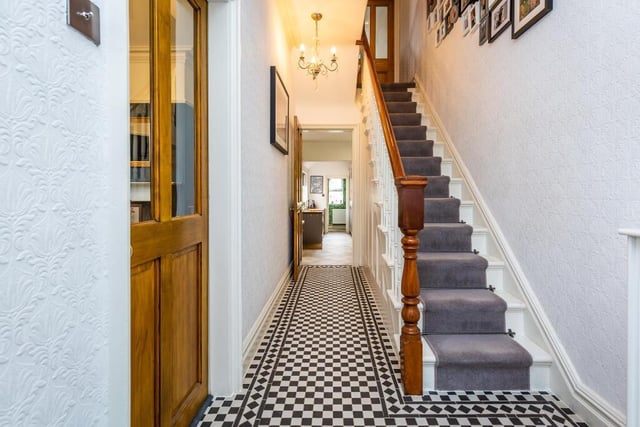 An inviting hallway with traditional style tiled floor.