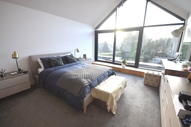 A double bedroom with a stunning large window looking over the garden.