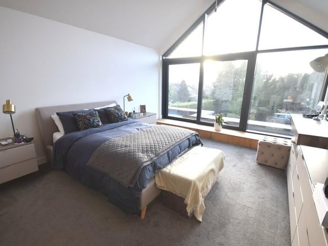 A double bedroom with a stunning large window looking over the garden.