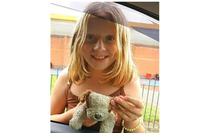 Georgie beams with delight after being reunited with her beloved soft toy.