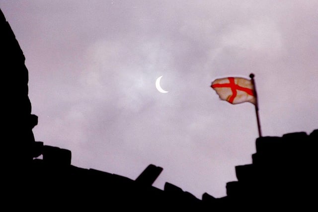 The solar eclipse seen from the grounds of Conisbrough Castle. The flag is that of St George which flies from the top of the keep, August 11, 1999
