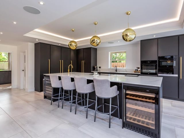 A sleek and modern kitchen with large island and breakfast bar.