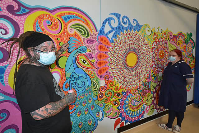 John and Morag alongside the mural