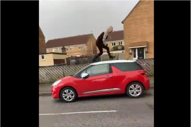 The clip shows a hooded youth running across the top of a car in Doncaster.