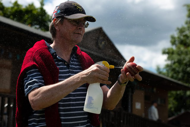 Hambledon Cricket Club member Ian Pratt disinfects the ball during the interval. Pic: Jordan Pettitt/Solent News & Photo Agency