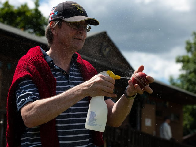 Hambledon Cricket Club member Ian Pratt disinfects the ball during the interval. Pic: Jordan Pettitt/Solent News & Photo Agency