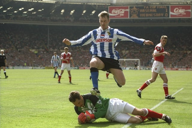 Wednesday's John Sheridan leaps over Arsenal goalkeeper David Seaman during the FA Cup final at Wembley in May 1993. The game finished 1-1, with the Owls losing the replay five days later.