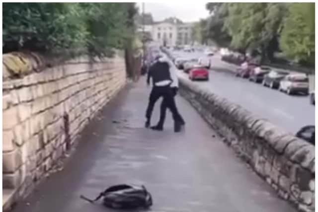 Footage shows two people locked in a violent struggle outside Hall Cross Academy.
