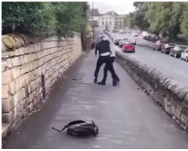 Footage shows two people locked in a violent struggle outside Hall Cross Academy.