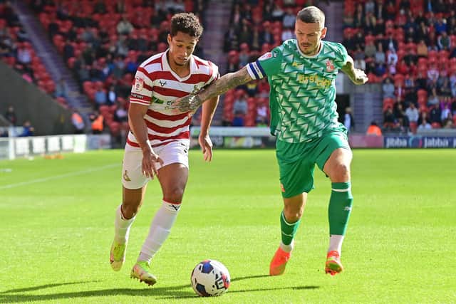 Doncaster's Kyle Knoyle battles with Swindon's Angus MacDonald.