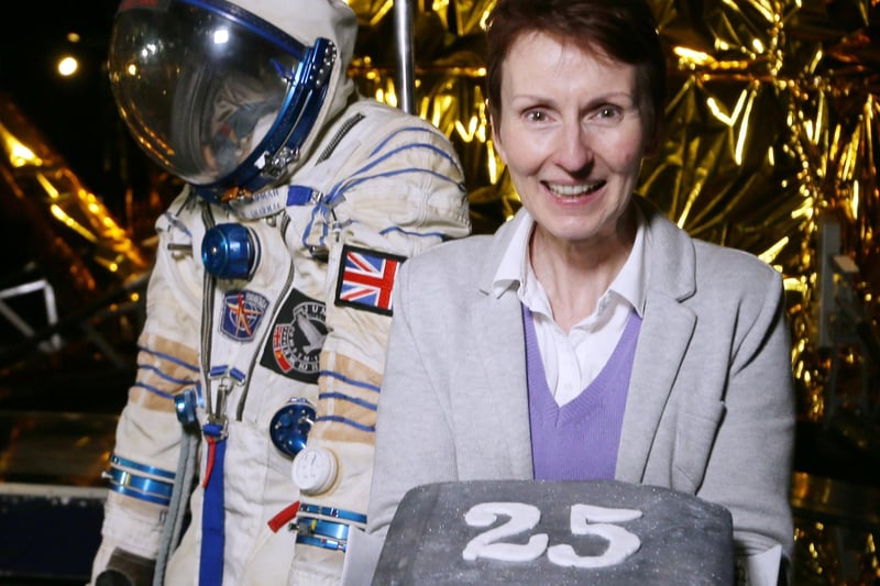 Britain's first astronaut Helen Sharman holds an anniversary cake at the Science Museum in London in 2016 as she stands with the space suit she wore 25 years ago on her journey into space