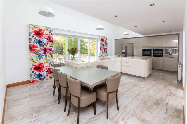 The large L-shaped central island with Silestone work surface has discrete electric sockets and acts as the central hub to the home, while the part-vaulted ceiling and sky lights ensure maximum natural light.