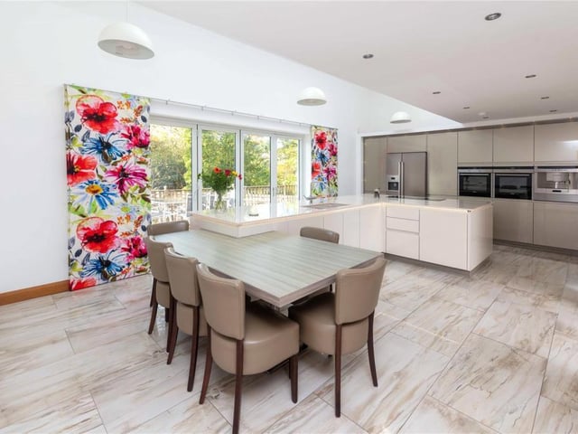 The large L-shaped central island with Silestone work surface has discrete electric sockets and acts as the central hub to the home, while the part-vaulted ceiling and sky lights ensure maximum natural light.