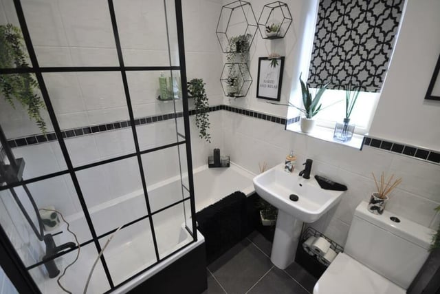 A modern bathroom with white suite.