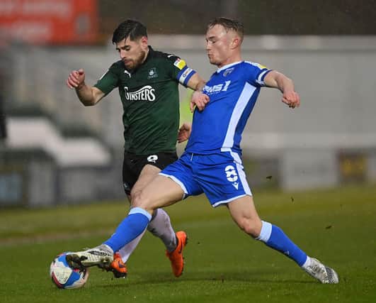 PLYMOUTH, ENGLAND - JANUARY 02: Joe Edwards of Plymouth Argyle is tackled by Kyle Dempsey of Gillingham during the Sky Bet League One match between Plymouth Argyle and Gillingham at Home Park on January 02, 2021 in Plymouth, England. The match will be played behind closed doors as a Covid-19 precaution. (Photo by Dan Mullan/Getty Images)
