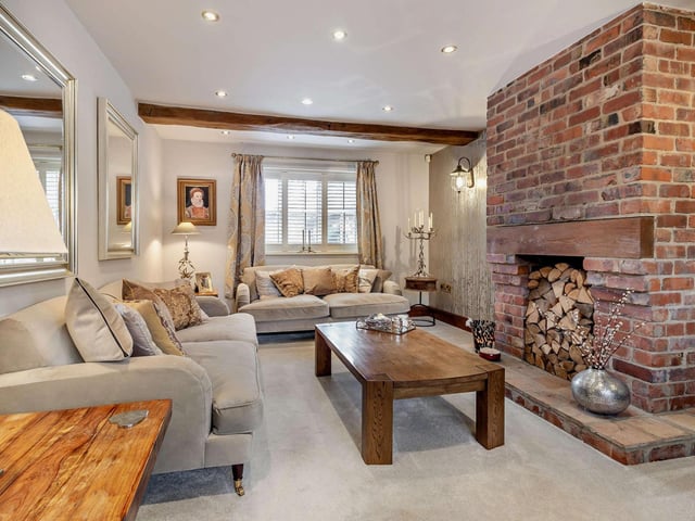 Relaxed lounge space with a feature exposed brick chimney breast with fireplace.
