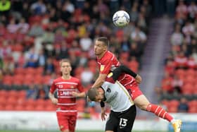 Doncaster's Tommy Rowe tussles for the ball with Portsmouth's Kieron Freeman at the Eco-Power Stadium last season.
