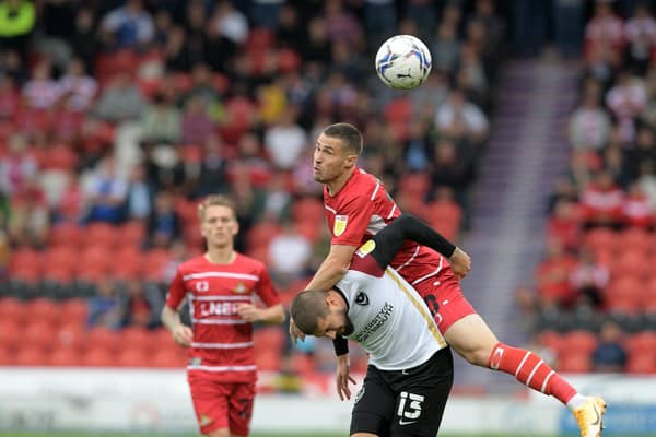 Doncaster's Tommy Rowe tussles for the ball with Portsmouth's Kieron Freeman at the Eco-Power Stadium last season.