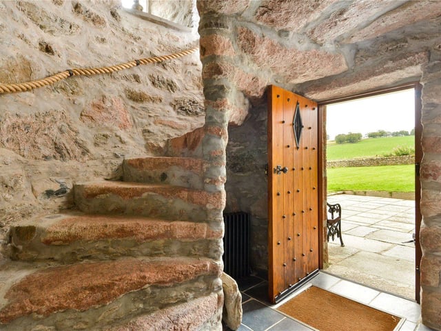 Entry to the historical tower house is through a studded, wood panelled front door.