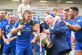 Dons chief executive Carl Hall celebrates promotion with the players.