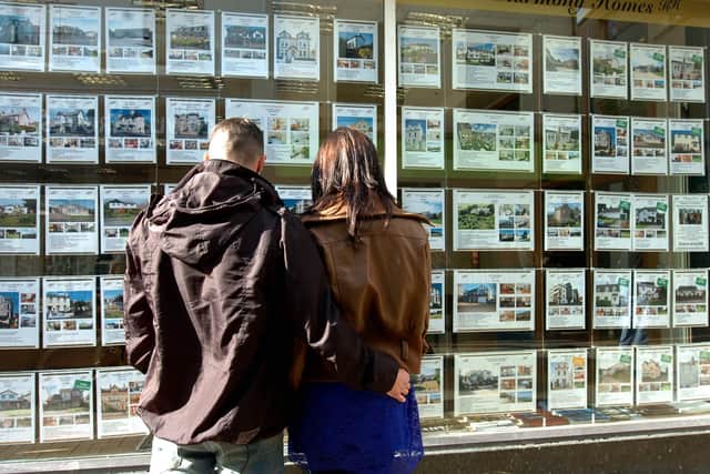 First time buyers looking at property adverts in an estate agent's window. Picture: JPIMedia.