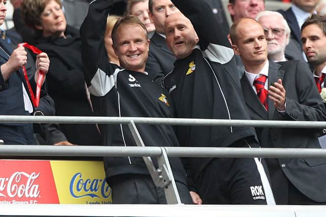 Sean O'Driscoll lifts the trophy alongside assistant Richard O'Kelly