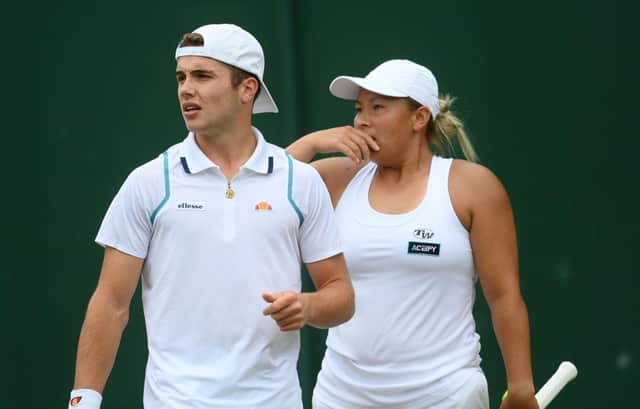 Arthur Fery and Tara Moore discuss tactics in their mixed doubles second round match at Wimbledon. Photo by Mike Hewitt/Getty Images