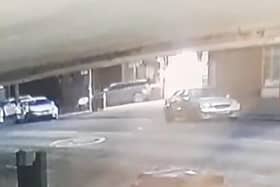 The car (centre) can be seen deliberately reversing into the barber shop before driving off at high speed.