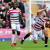 Doncaster's Adam Clayton is brought down by Bradford's skipper Richie Smallwood.