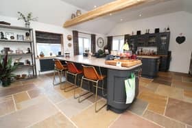 The spacious open plan kitchen has bespoke units with granite worktops, and integrated appliances.