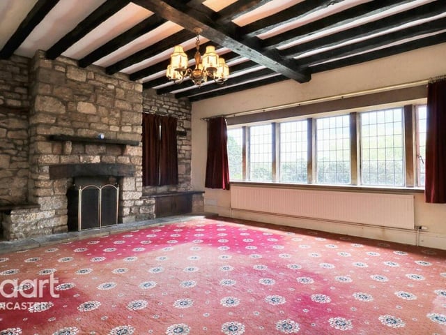 Another sizeable ground floor room with beamed ceiling, fireplace, and exposed stonework.