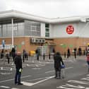 Shoppers queue using social distancing outside an Asda supermarket (Photo by OLI SCARFF/AFP via Getty Images)