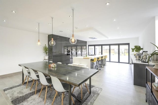 The sleek kitchen with dining area has bi-fold doors out to the patio.