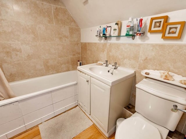 The bathroom suite includes a wash basin with vanity unit.